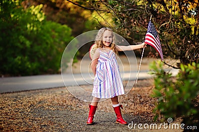 Happy adorable little girl smiling and waving American flag outs Stock Photo