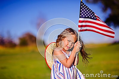 Happy adorable little girl smiling and waving American flag outs Stock Photo