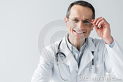 happy adult doctor sitting at workplace and looking at camera Stock Photo