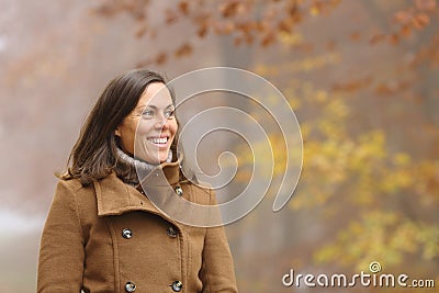 Happy adult lady contemplating walks in a park in fall Stock Photo