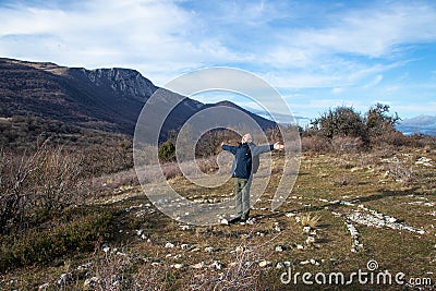 Happy adult man, stands in the center of a spiral laid out of stones Stock Photo