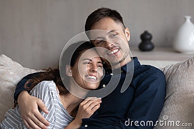 Happy affectionate young hispanic couple daydreaming at home. Stock Photo