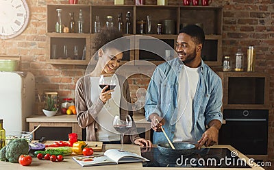 African-american couple cooking dinner and drinking red wine Stock Photo