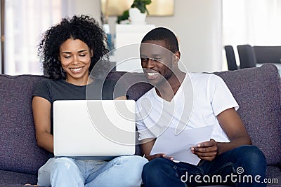 Happy African American couple using laptop, receive good news Stock Photo