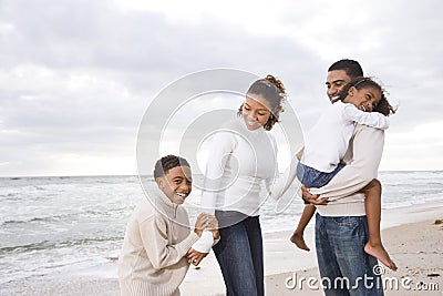 Happy African-American family of four on beach Stock Photo