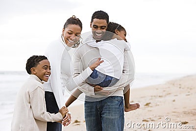 Happy African-American family of four on beach Stock Photo