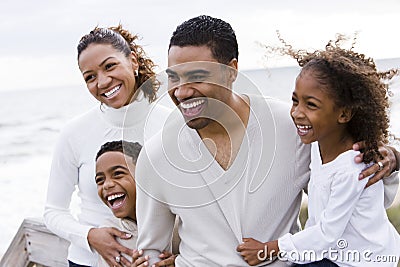 Happy African-American family of four on beach Stock Photo