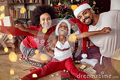 Happy African American family in front of Christmas tree Stock Photo