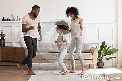 Happy african american family having fun, dancing at home. Stock Photo