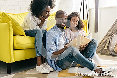 happy african american family reading book together Stock Photo