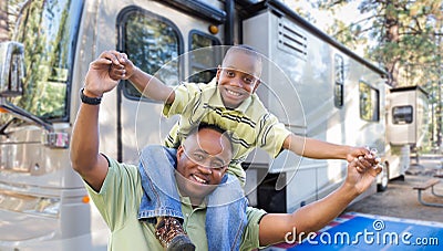 Happy African American Father and Son In Front of Their RV Stock Photo