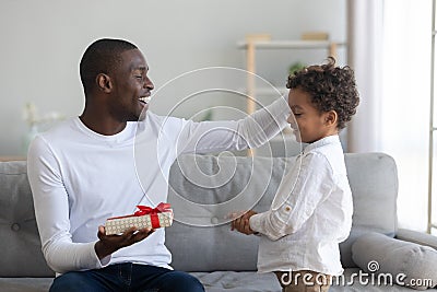 Happy African American father thanking cute little son for gift Stock Photo