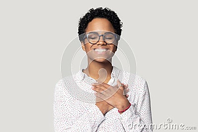 Smiling biracial woman with hands at chest feel thankful Stock Photo