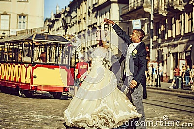 Happy african American groom and cute bride dancing on street Stock Photo