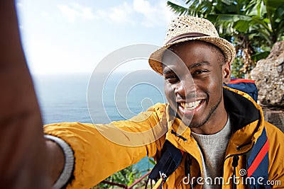 Happy african american male hiker with backpack taking selfie Stock Photo