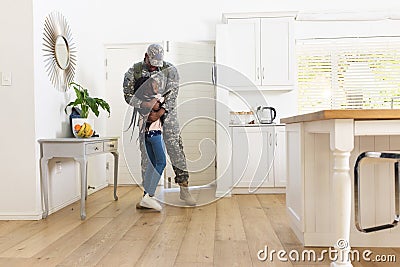 Happy african american male soldier embracing daughter at home, copy space Stock Photo