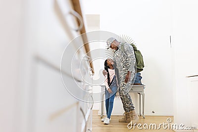 Happy african american male soldier embracing daughter at home, copy space Stock Photo