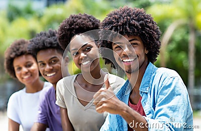 Happy african american man with group of young adults in line Stock Photo