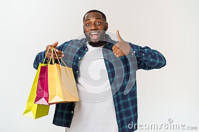 Happy african american man holding shopping bags on white background. Holidays concept Stock Photo