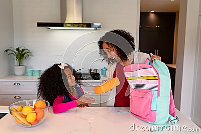Happy african american mother and daughter preparing lunchbox for school Stock Photo
