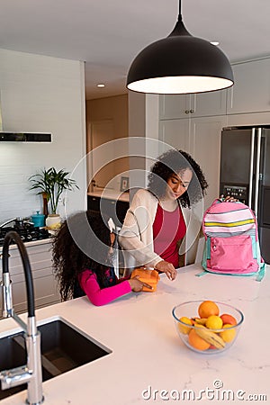 Happy african american mother and daughter preparing lunchbox for school Stock Photo