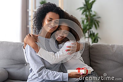 Happy mom hugging daughter thanking for present Stock Photo