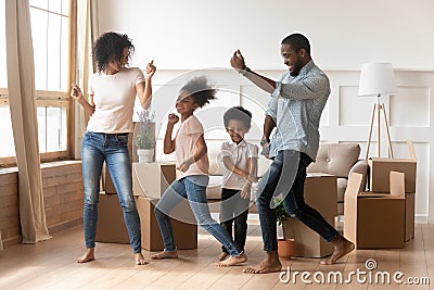 Happy african american parents and children dancing celebrating moving day Stock Photo