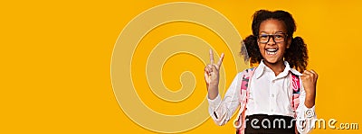 Happy African American Schoolgirl Gesturing Victory Sign In Studio Stock Photo