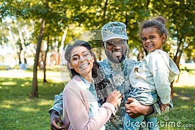 happy african american soldier in military uniform looking at camera with family Stock Photo