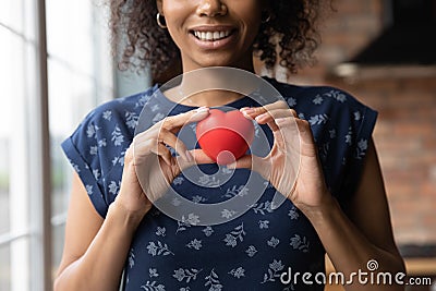 Happy African American volunteer girl holding red heart Stock Photo