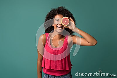 Happy african-american woman holding half of grapefruit Stock Photo