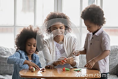 Happy African American woman with and kids playing with plasticine Stock Photo