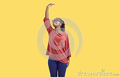 Happy African American woman measuring her height as metaphor for personal growth Stock Photo