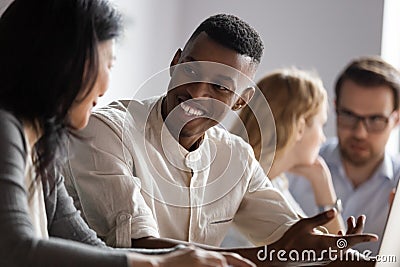 Happy african american young worker discussing project ideas with leader. Stock Photo