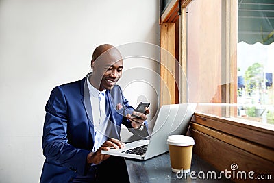 Happy african businessman using phone at cafe Stock Photo