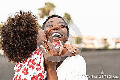 Happy African family on the beach during summer holidays - Afro American people having fun on vacation time Stock Photo