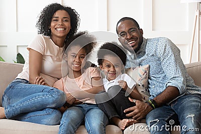 Happy african family of four looking at camera at home Stock Photo