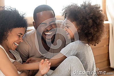 Happy african family with kid daughter tickling laughing together Stock Photo