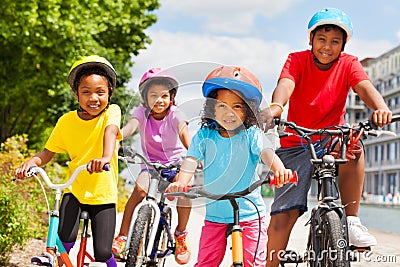 Happy African siblings riding bikes in summer city Stock Photo