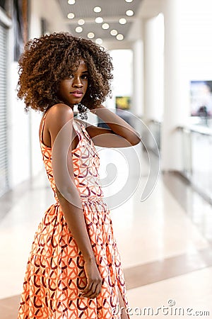 Happy african woman in beautiful dress in a shopping mall. Stock Photo