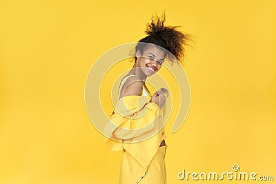 Happy afro girl wear stylish yellow cloth dance isolated on yellow background. Stock Photo