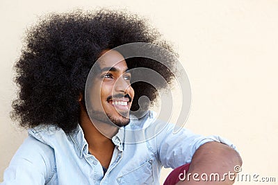 Happy afro man sitting and looking away Stock Photo