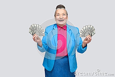 Happy aged woman holding many american dollars Stock Photo