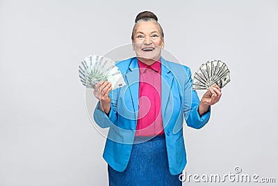 Happy aged woman holding many euro and dollars Stock Photo