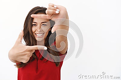 Happy ambitious lucky girl aim only success, looking for inspiration. Cheerful young woman making hand frames and Stock Photo