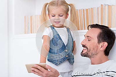 Happy amused father and daughter looking at the screen Stock Photo