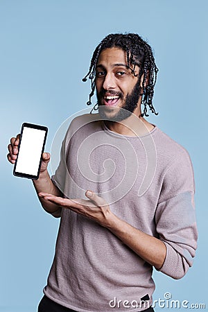 Happy arab advertiser holding smartphone with blank white screen Stock Photo