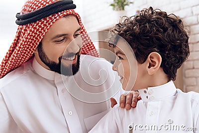 Happy Arab father holds small son by shoulder. Stock Photo