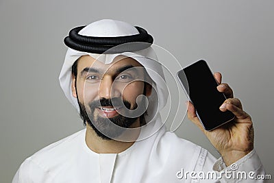 A Happy Arab Man Holding A Mobile Phone Stock Photo