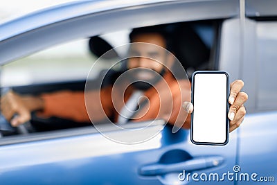 Happy Arabic Guy Sitting Inside Car Displaying Smartphone Empty Screen Stock Photo